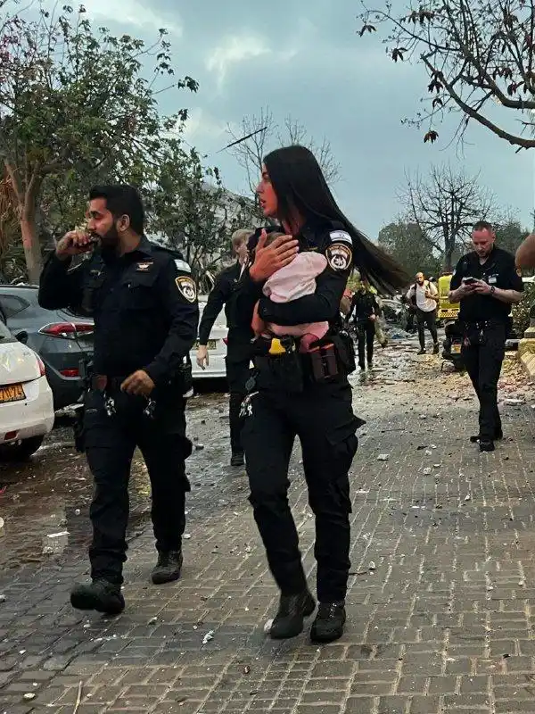Image from Enlace Judío : 🚨 *Conmueve en redes fotografía de una policía cargando a un bebé tra...