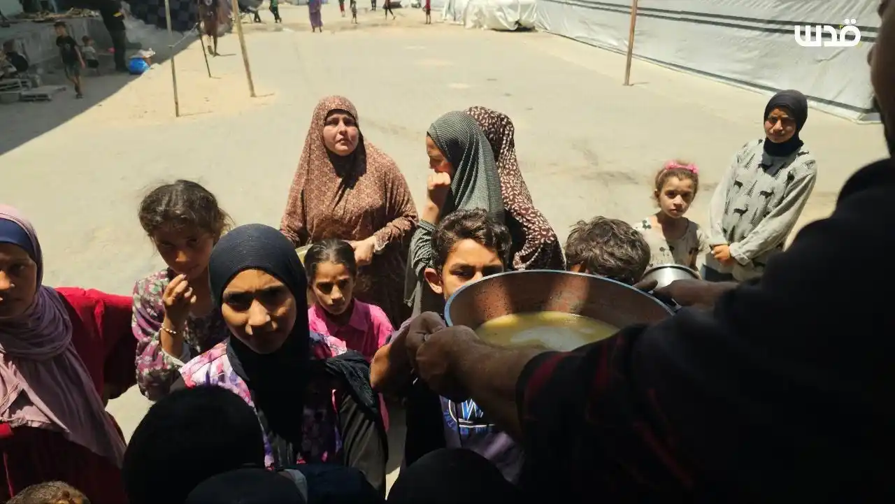 Image from Quds News Network: Palestinians, including children, try to get small amounts of food fro...